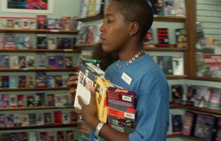 Grainy image of woman with arms full of VHS tapes